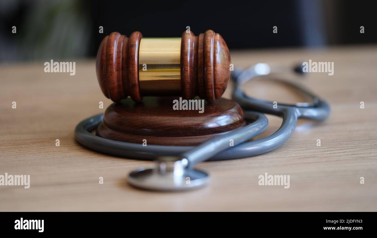 Judge gavel and doctor stethoscope on lawyer office desk Stock Photo