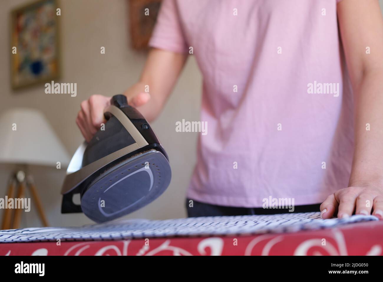 Housewife ironing bed linen on board using steam iron Stock Photo Alamy