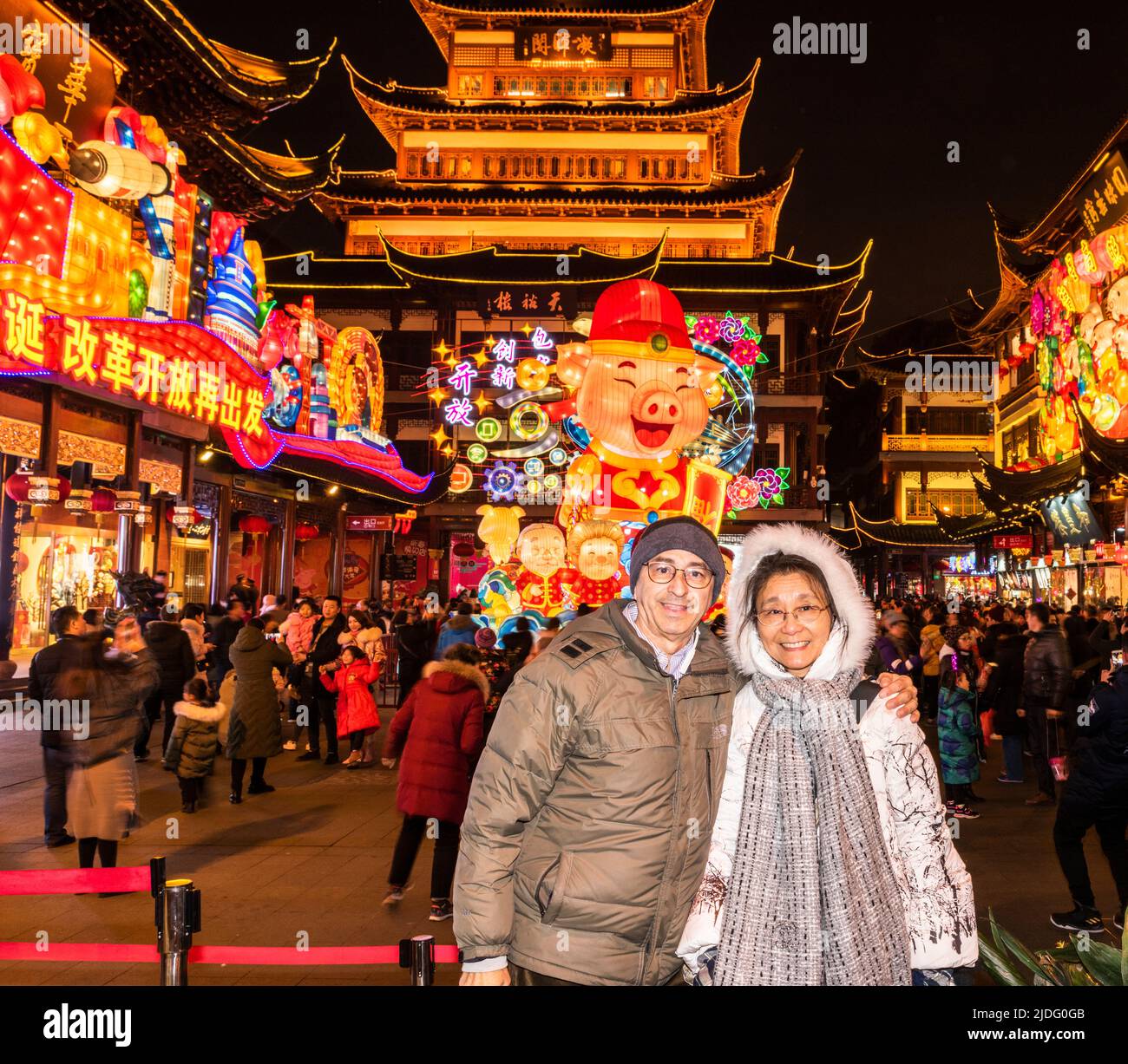 A couple pose in front of the Year of the Pig display at Yu Yuan, Yu Garden Yixiulou building in Old Shanghai. Stock Photo