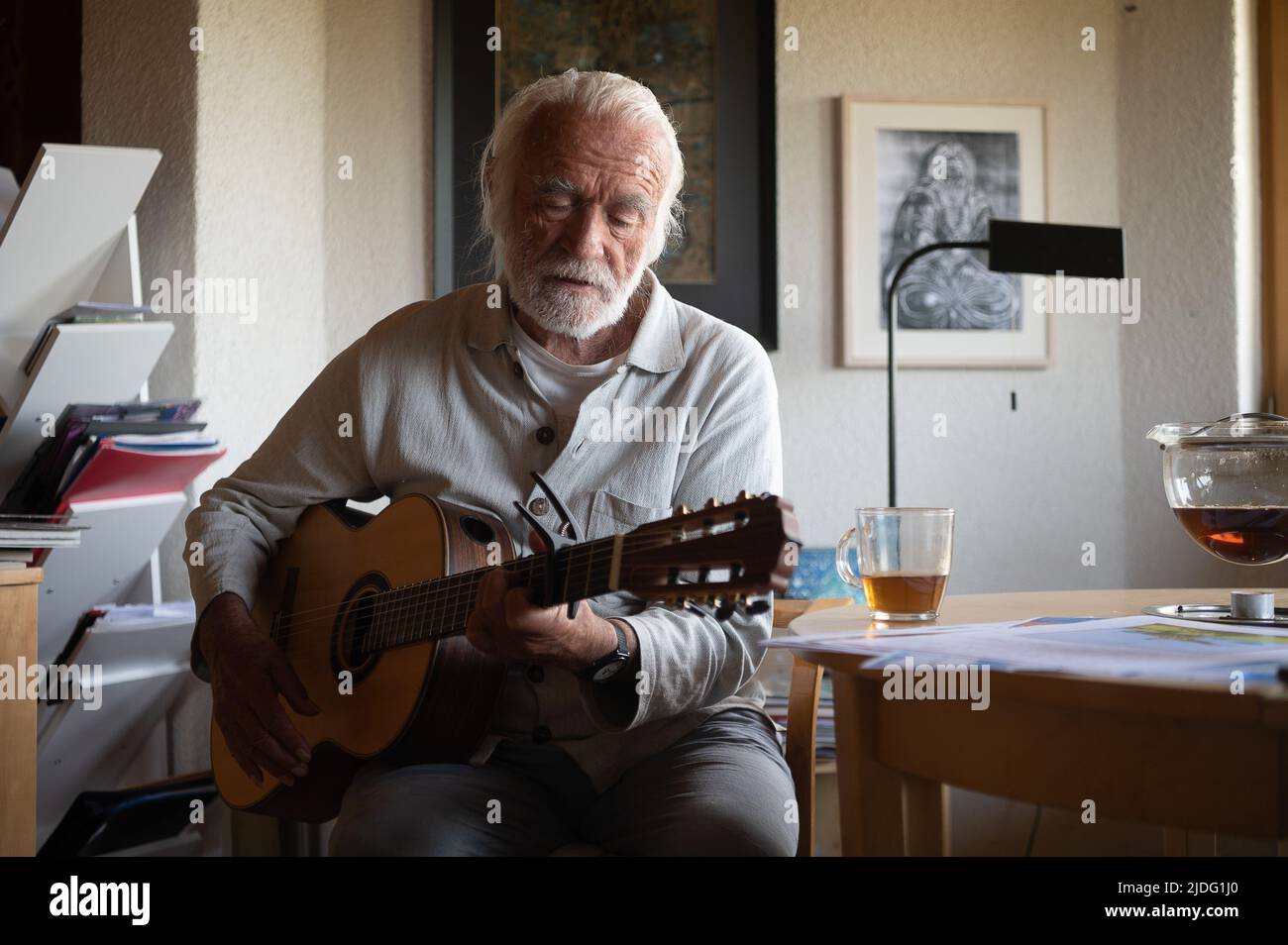 Lollar, Germany. 14th June, 2022. Children's songwriter Fredrik Vahle plays guitar in his home during an interview. He celebrates his 80th birthday on June 24. Credit: Sebastian Gollnow/dpa/Alamy Live News Stock Photo