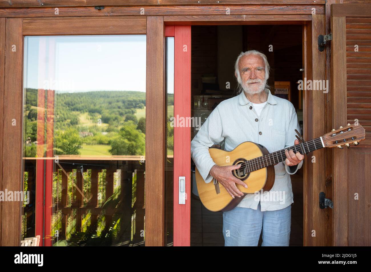 Lollar, Germany. 14th June, 2022. Children's songwriter Fredrik Vahle stands in his house with a guitar. He celebrates his 80th birthday on June 24. (to dpa 'Songwriter Vahle: Children are hungry for cultural impulses') Credit: Sebastian Gollnow/dpa/Alamy Live News Stock Photo