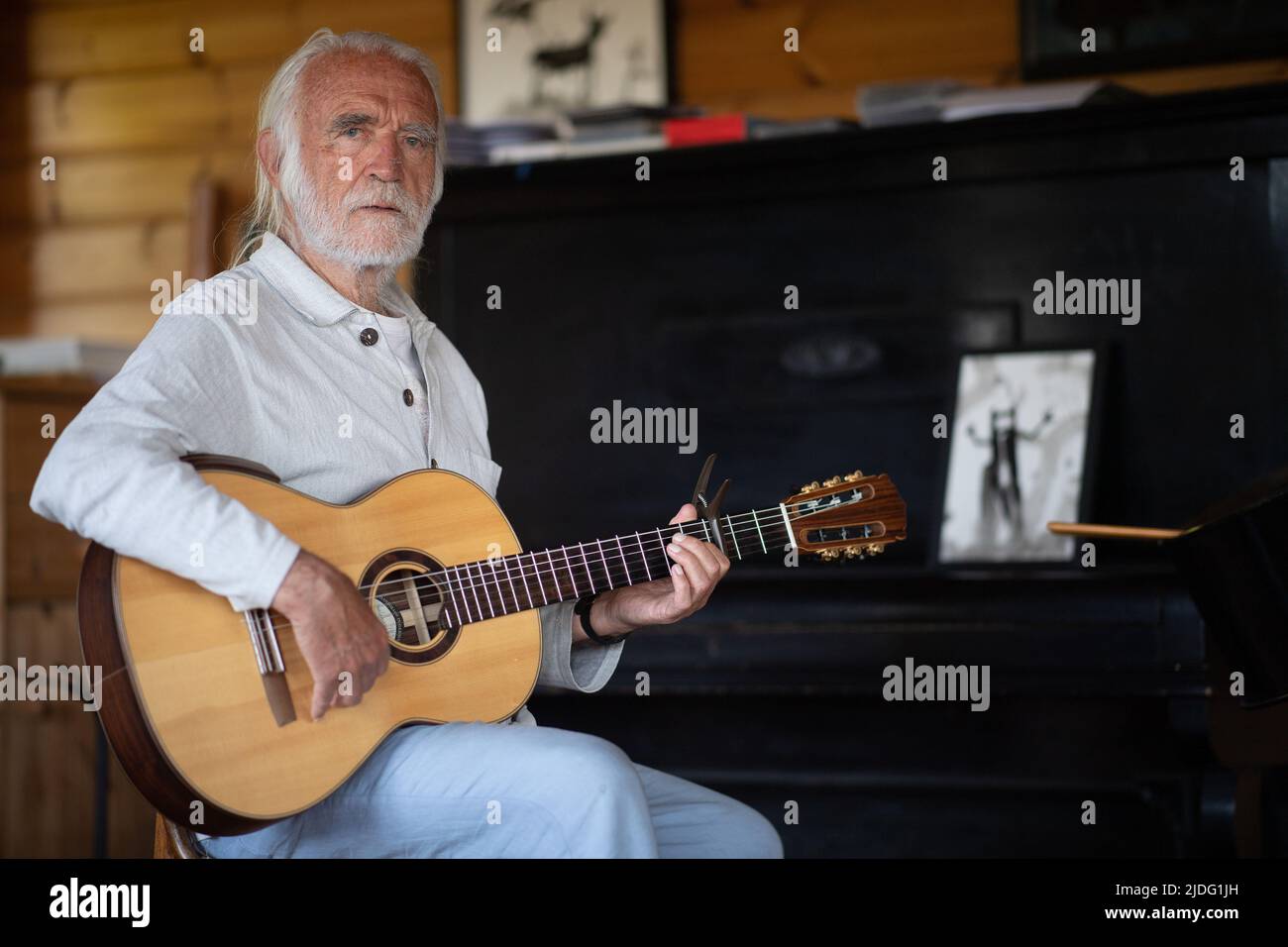 Lollar, Germany. 14th June, 2022. Children's songwriter Fredrik Vahle sits with a guitar in his house. He celebrates his 80th birthday on June 24. (to dpa 'Songwriter Vahle: Children are hungry for cultural impulses') Credit: Sebastian Gollnow/dpa/Alamy Live News Stock Photo