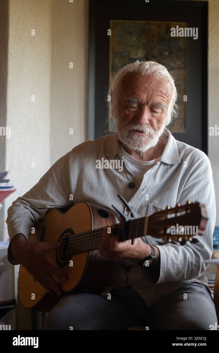 Lollar, Germany. 14th June, 2022. Children's songwriter Fredrik Vahle plays guitar in his home during an interview. He celebrates his 80th birthday on June 24. (to dpa 'Songwriter Vahle: Children are hungry for cultural impulses') Credit: Sebastian Gollnow/dpa/Alamy Live News Stock Photo