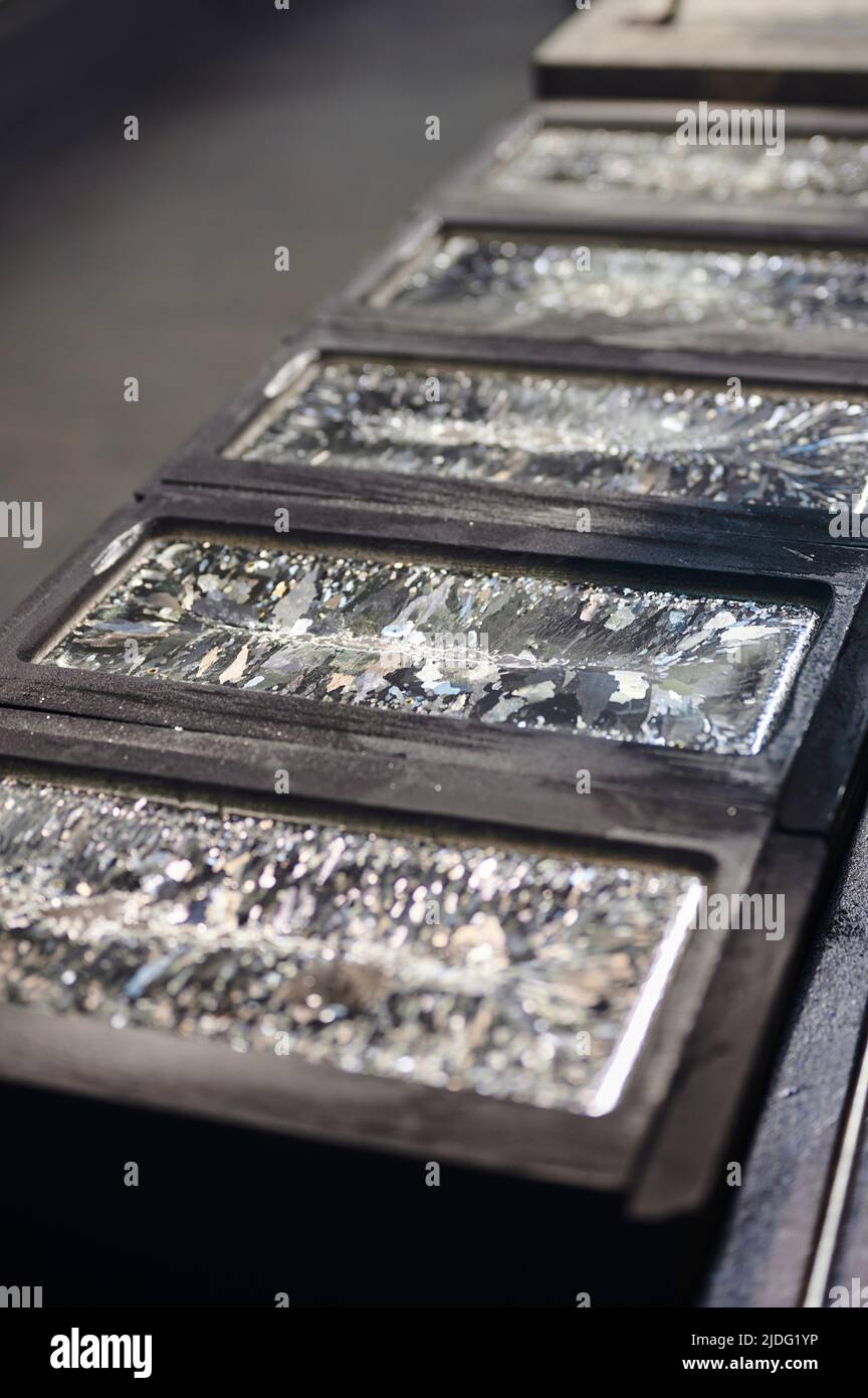 Silver bars chill down in graphite casting forms on table Stock Photo