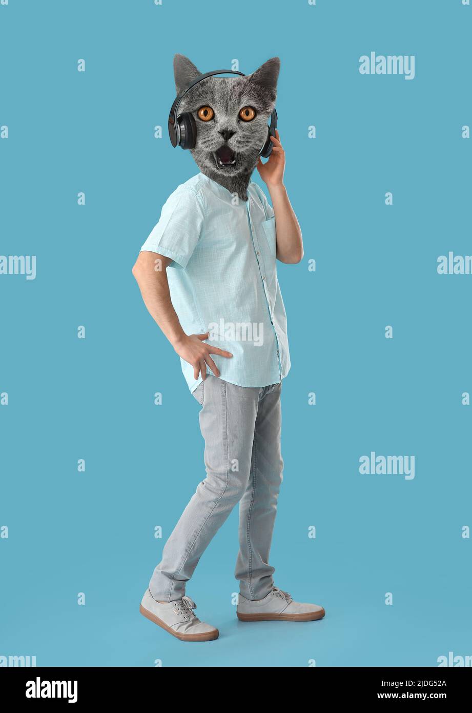 Funny grey cat with human body listening to music on blue background