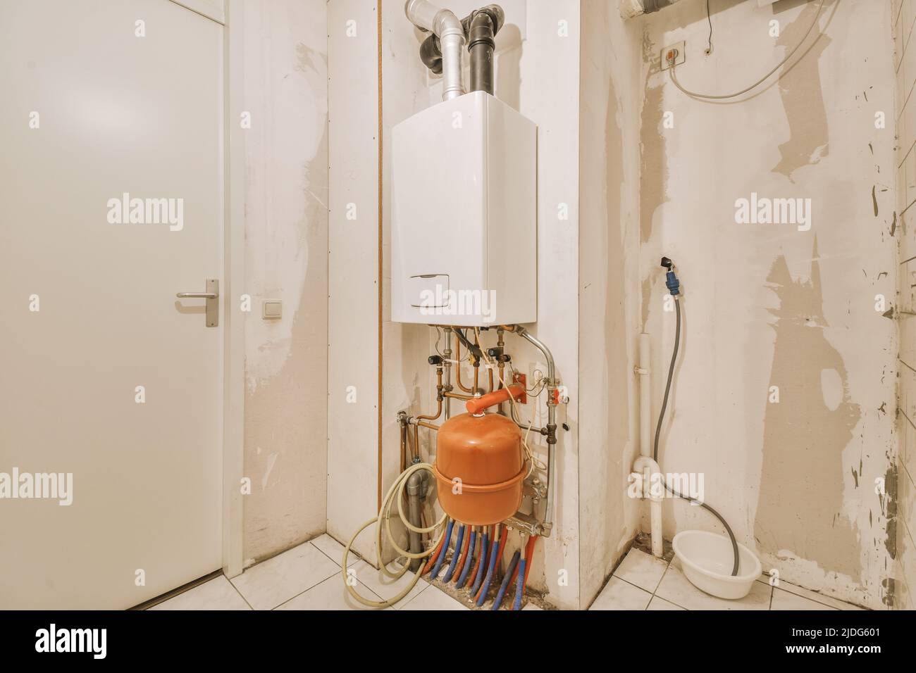 Boiler room of an apartment building with a boiler, pipes and metering devices. Small room with utilities in a modern apartment Stock Photo