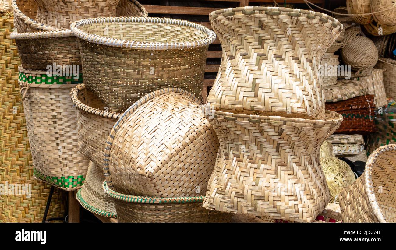 A pile of handmade traditional woven baskets made from straw, natural fiber, for sale at the outdoor market in Cuenca, Ecuador Stock Photo