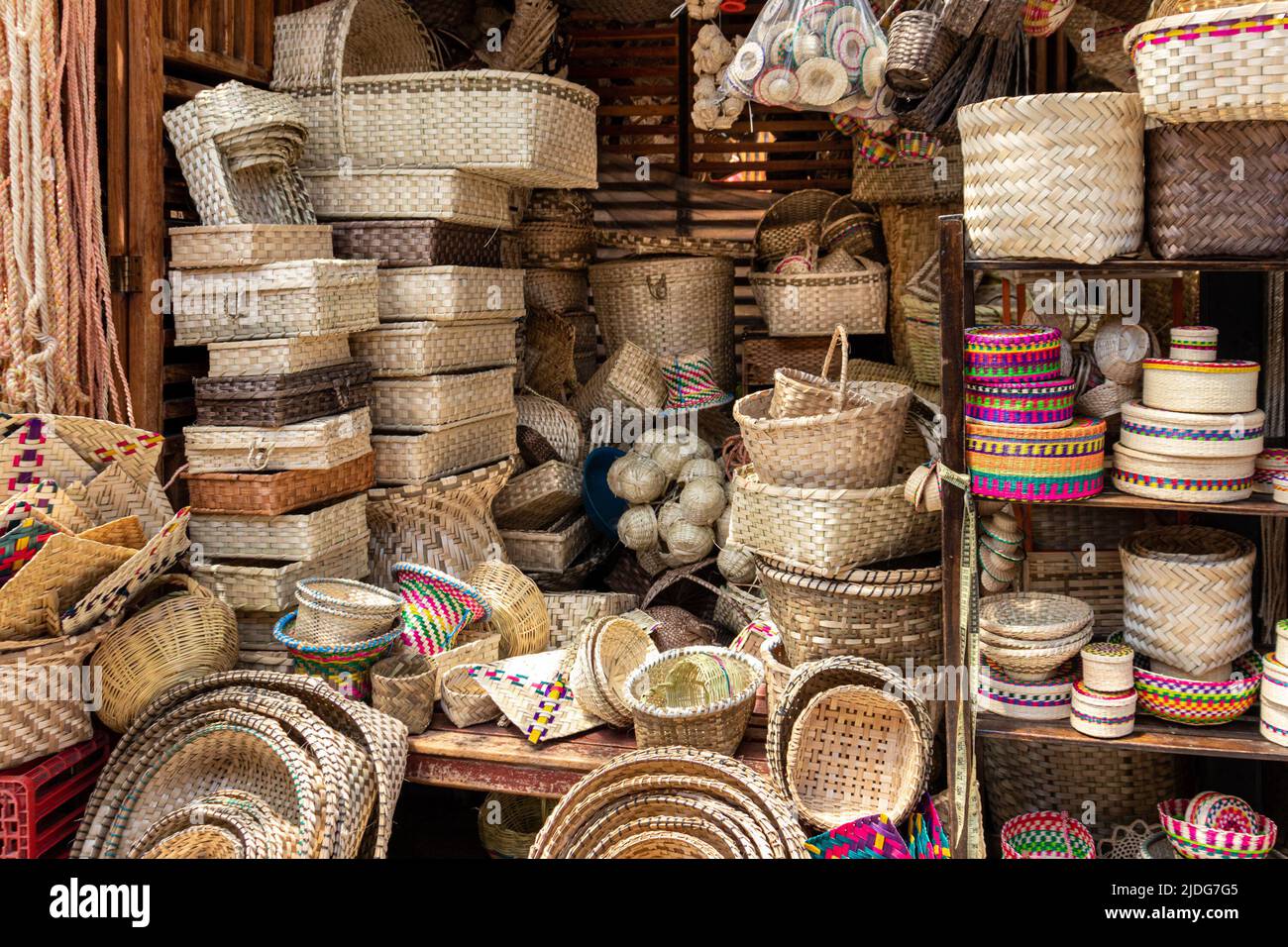 A pile of handmade traditional woven baskets made from straw, natural fiber, for sale at the outdoor market in Cuenca, Ecuador Stock Photo