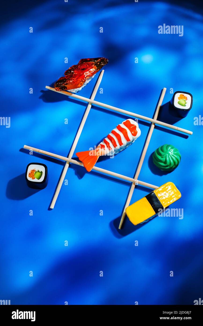 Asian food, sushi underwater, tic-tac-toe with chopsticks Stock Photo