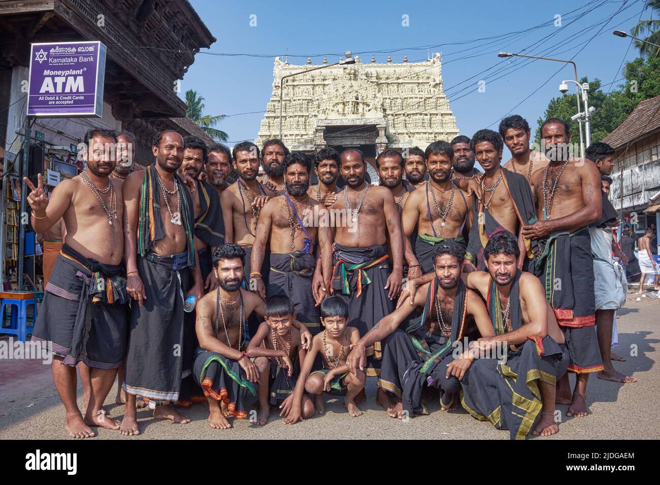 An all-male group of Hindu pilgrims, dressed in black dhotis, in front of Padmanabhaswamy Temple in Trivandrum (Thiruvananthapuram), Kerala, India Stock Photo