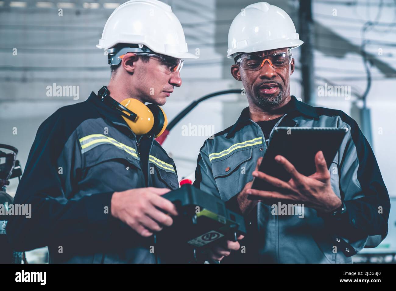 Group of factory job workers using adept machine equipment in a