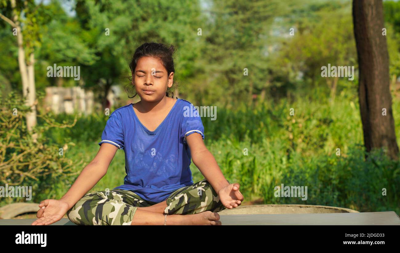 Indian Child doing exercise on platform outdoors. Healthy lifestyle. Yoga girl. Stock Photo