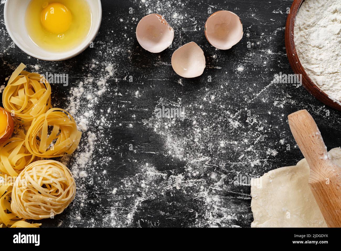 Raw egg pasta with flour on black background Stock Photo Alamy