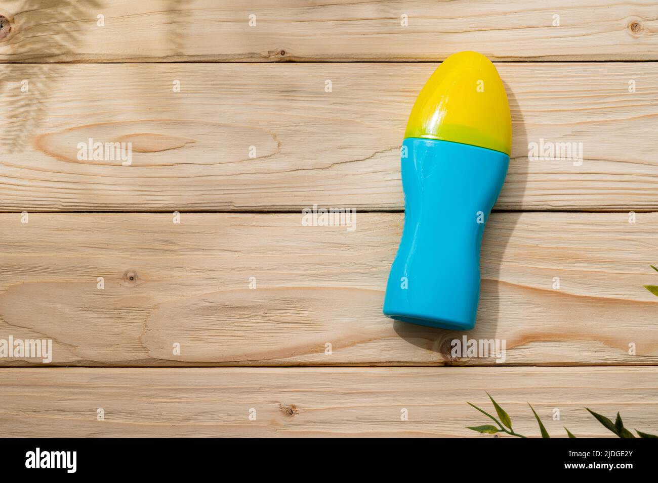 Bottle with sun protection cream on wooden background, top view Stock Photo