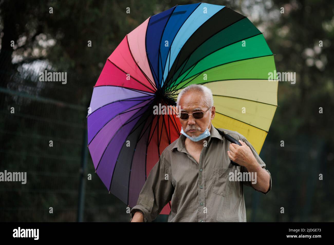 A man carries a parasol on a hot day on Summer Solstice in Beijing, China, June 21, 2022.  REUTERS/Thomas Peter Stock Photo