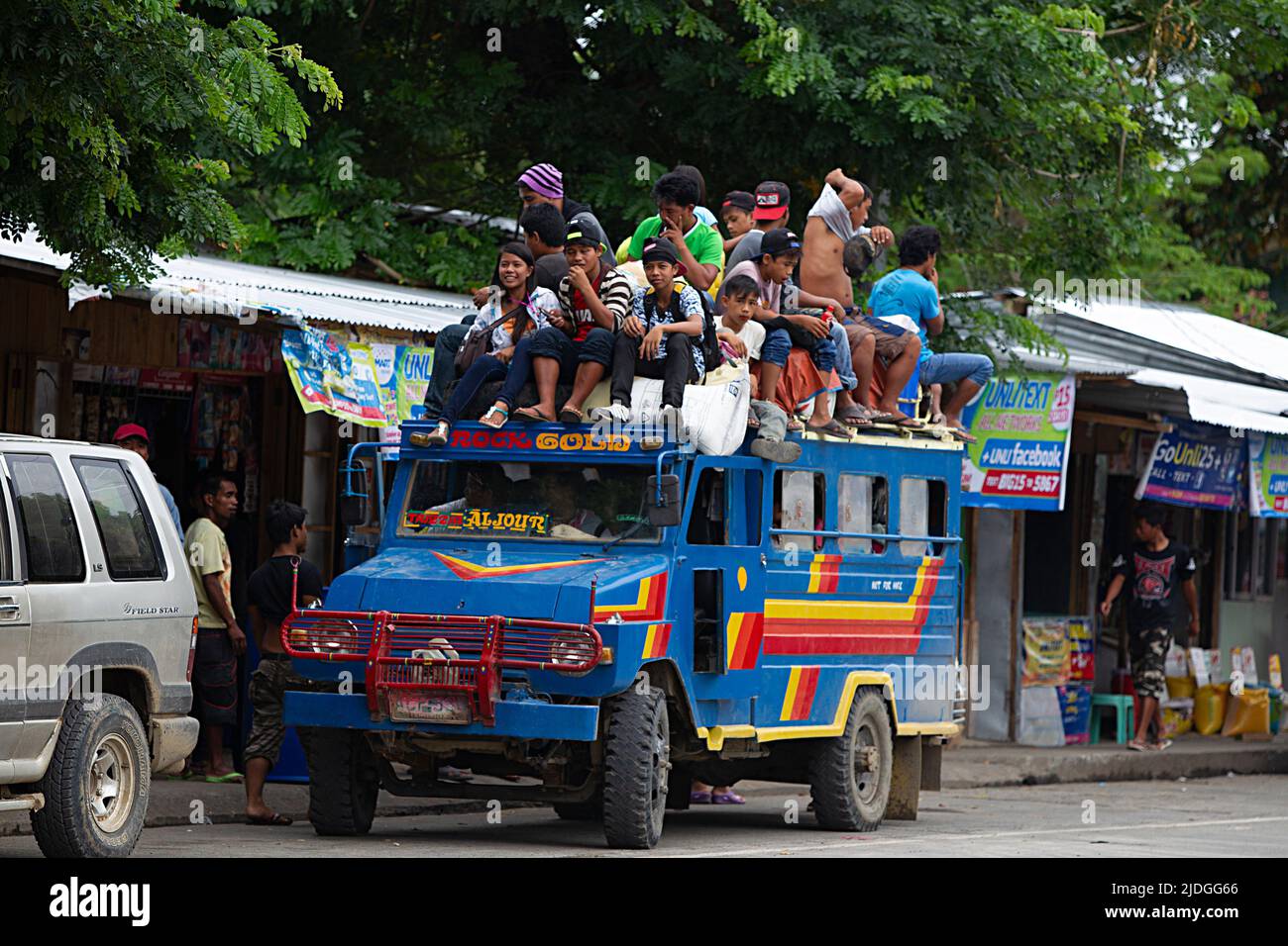 Philippine Jeepney vehicle carrying a load of passengers on the roof Stock Photo