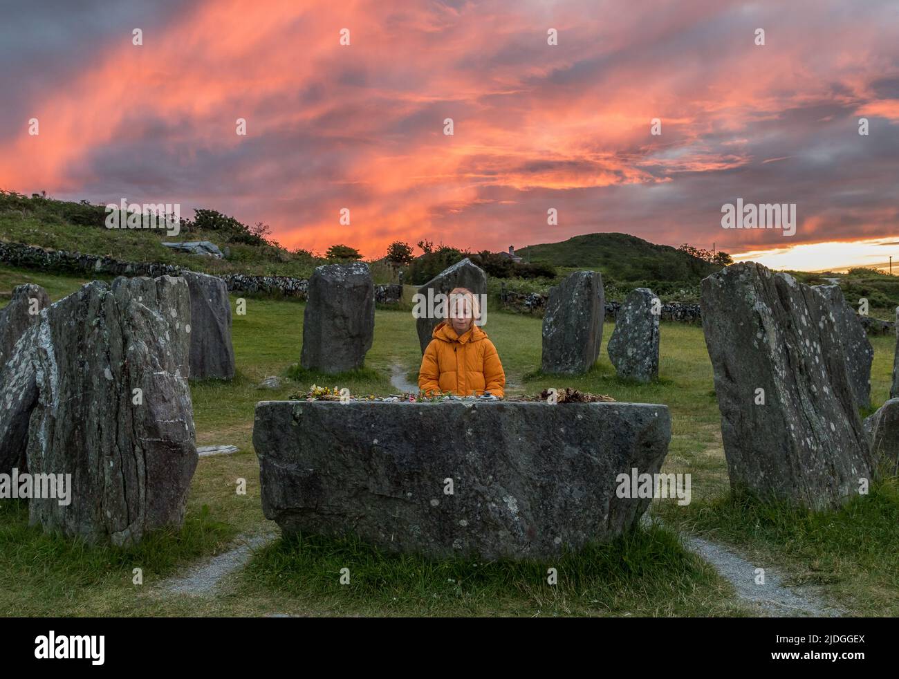 Drombeg, Glandore, Cork, Ireland. 21st June, 2022. As dawn breaks,a little girl looks at the offerings that have been placed on the Altar Stone during the Summer Solstice at Drumbeg Stone Circle, Glandore, Co. Cork, Ireland.  - Credit; David Creedon / Alamy Live News Stock Photo