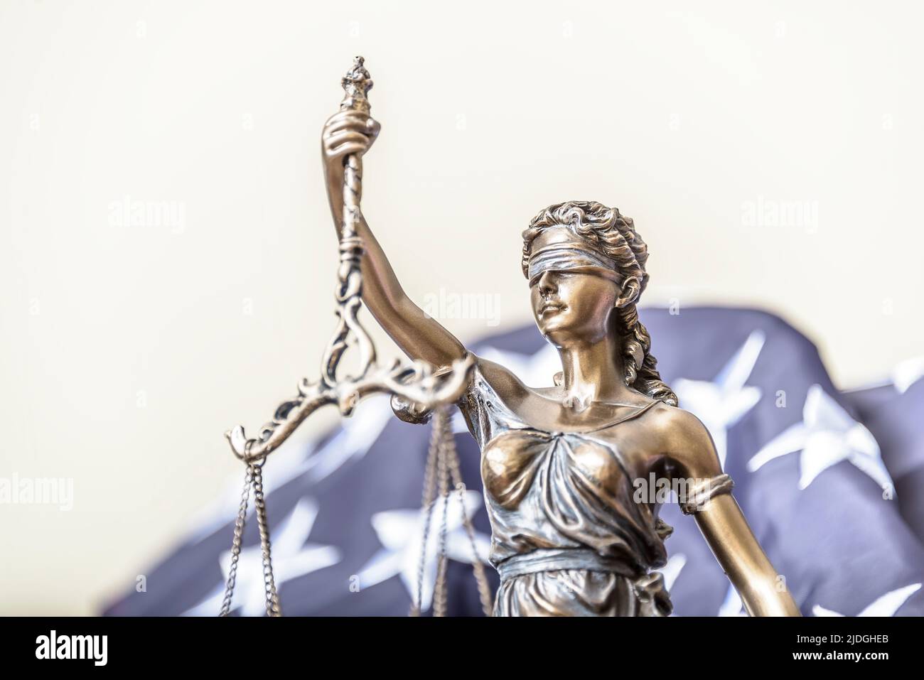 Bronze figurine of Themis holds wedding rings on scales of balance, being in foreground. Couple divorce. Stock Photo