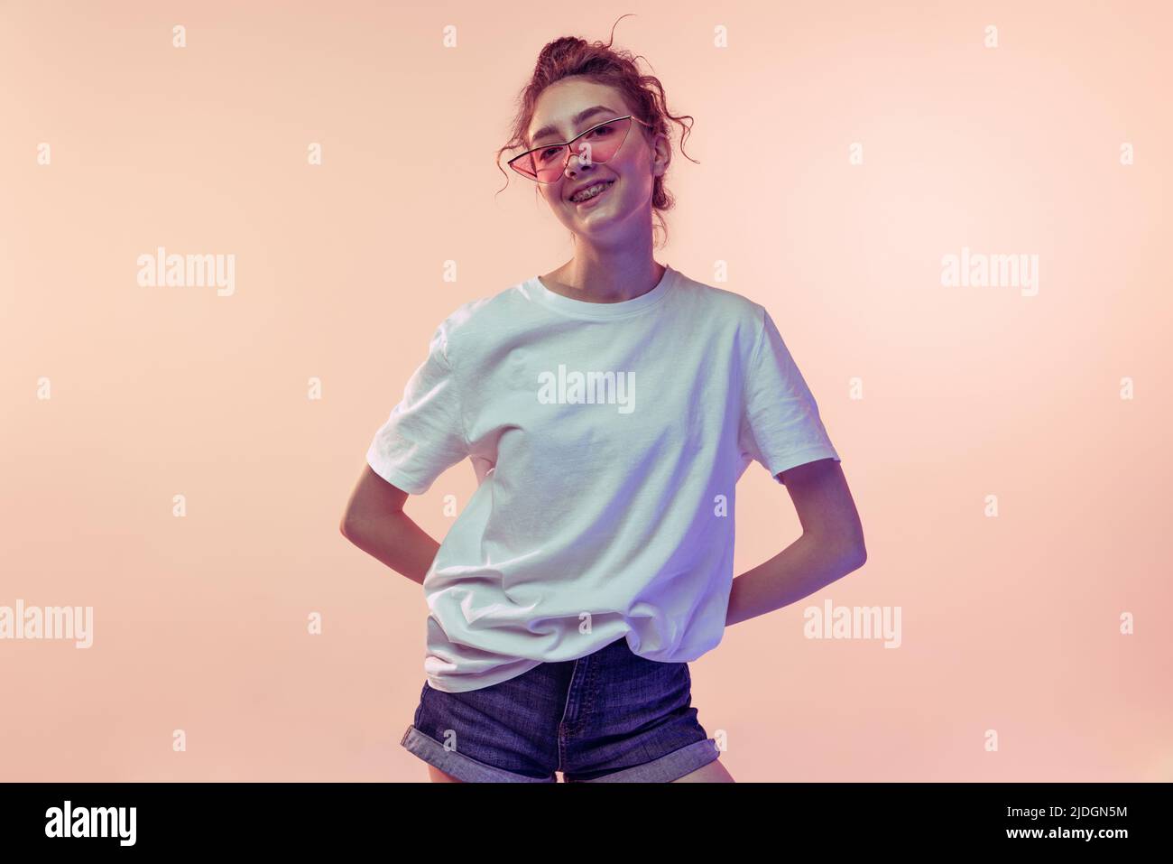 Portrait of stylish young girl wearing trendy sunglasses, posing in