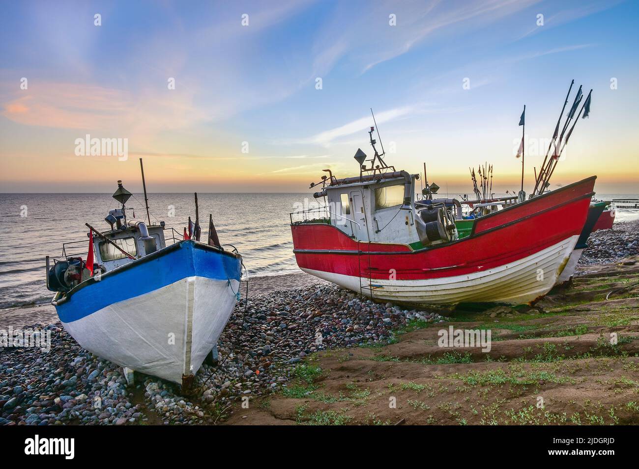 colorful fishing boats in the first rays of sun, the Baltic Sea in Poland Stock Photo