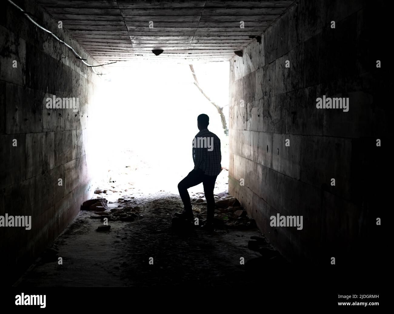 Close up photo of man hiding in the tunnel as a symbol of agoraphobia and timidity. Stock Photo