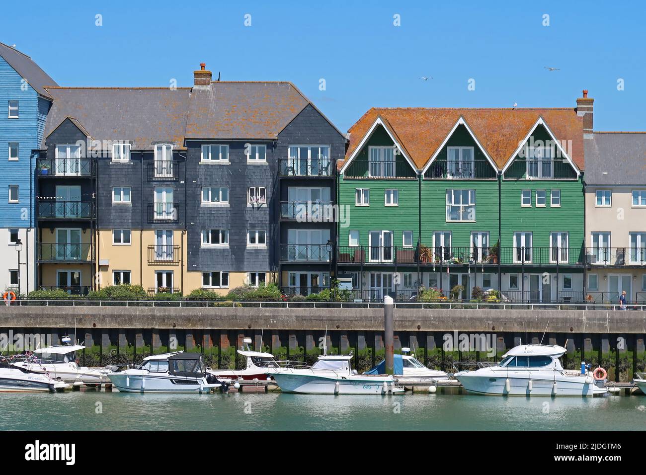 Littlehampton, West Sussex, UK. Recently developed waterfront housing on the East bank of the River Arun. Shows pontoon mooring and riverside footpath Stock Photo