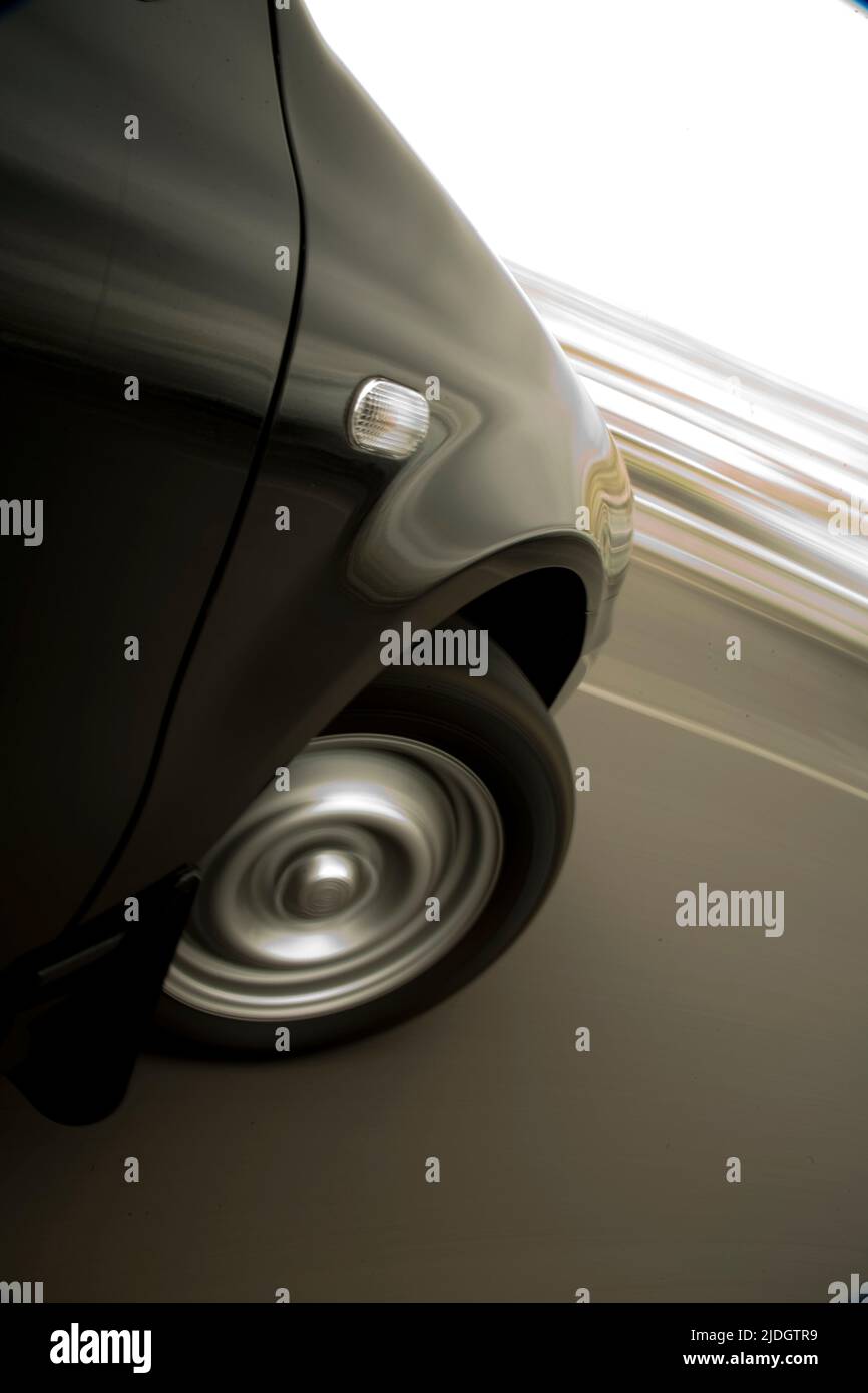 Black car turning sharply to its right, showing speed in tracking blur