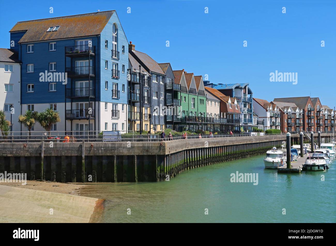 Littlehampton, West Sussex, UK. Recently developed waterfront housing on the East bank of the River Arun. Shows pontoon mooring and riverside footpath Stock Photo