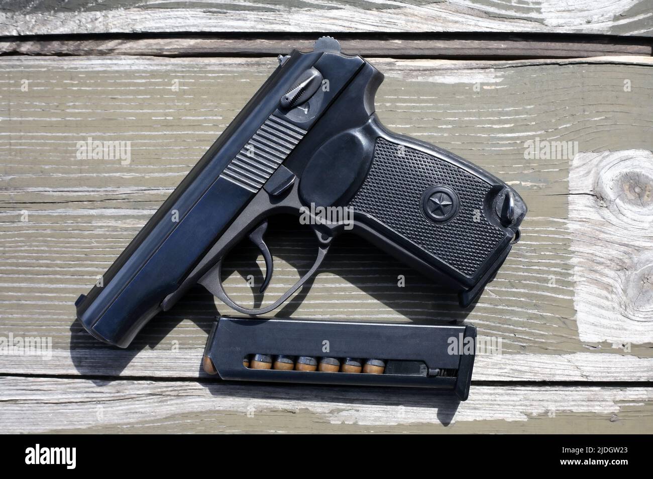 Eight-capacity magazine near handgun on wooden background Stock Photo