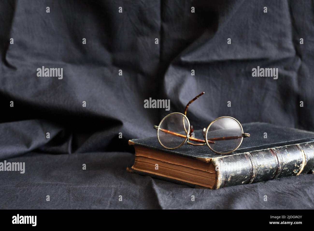 Old book and old glasses against dark textile beckground Stock Photo