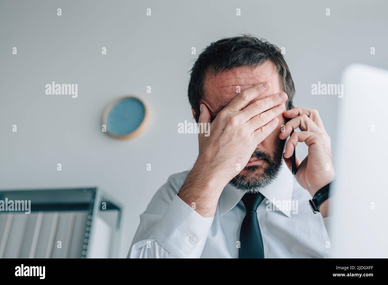 Business phone call failure, disappointed businessman using mobile phone in office, selective focus Stock Photo