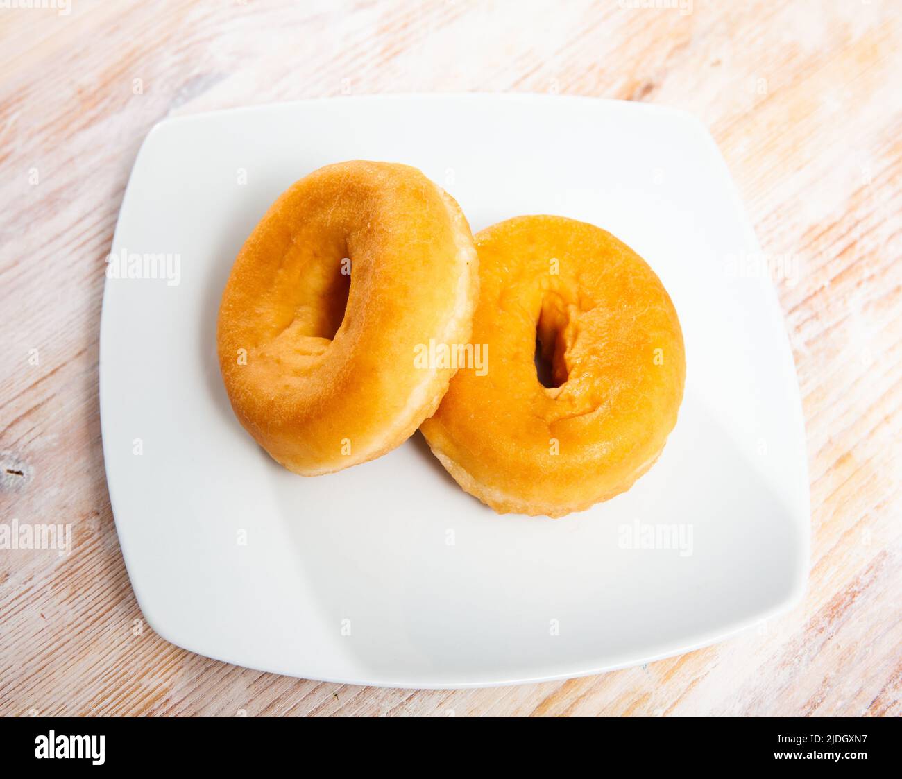 Two tasty donuts on wooden table Stock Photo