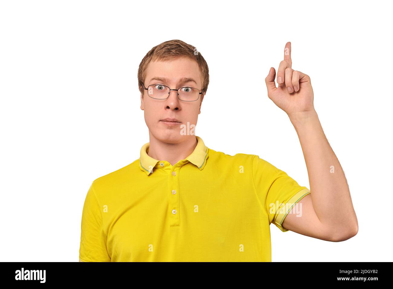 Funny young man in corrective glasses with eureka gesture, man got idea isolated on white background. Surprised geek man in yellow T-shirt pointing in Stock Photo