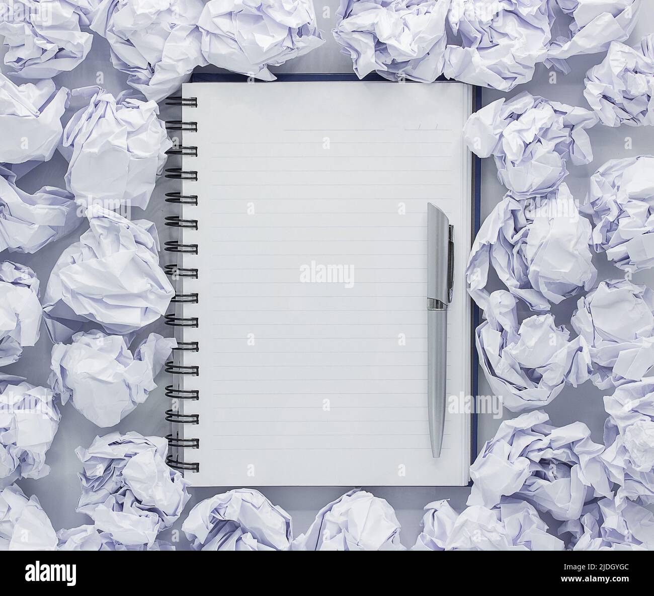 White note pad on white background. Around the notepads lies lot crumpled paper,Copy space Stock Photo