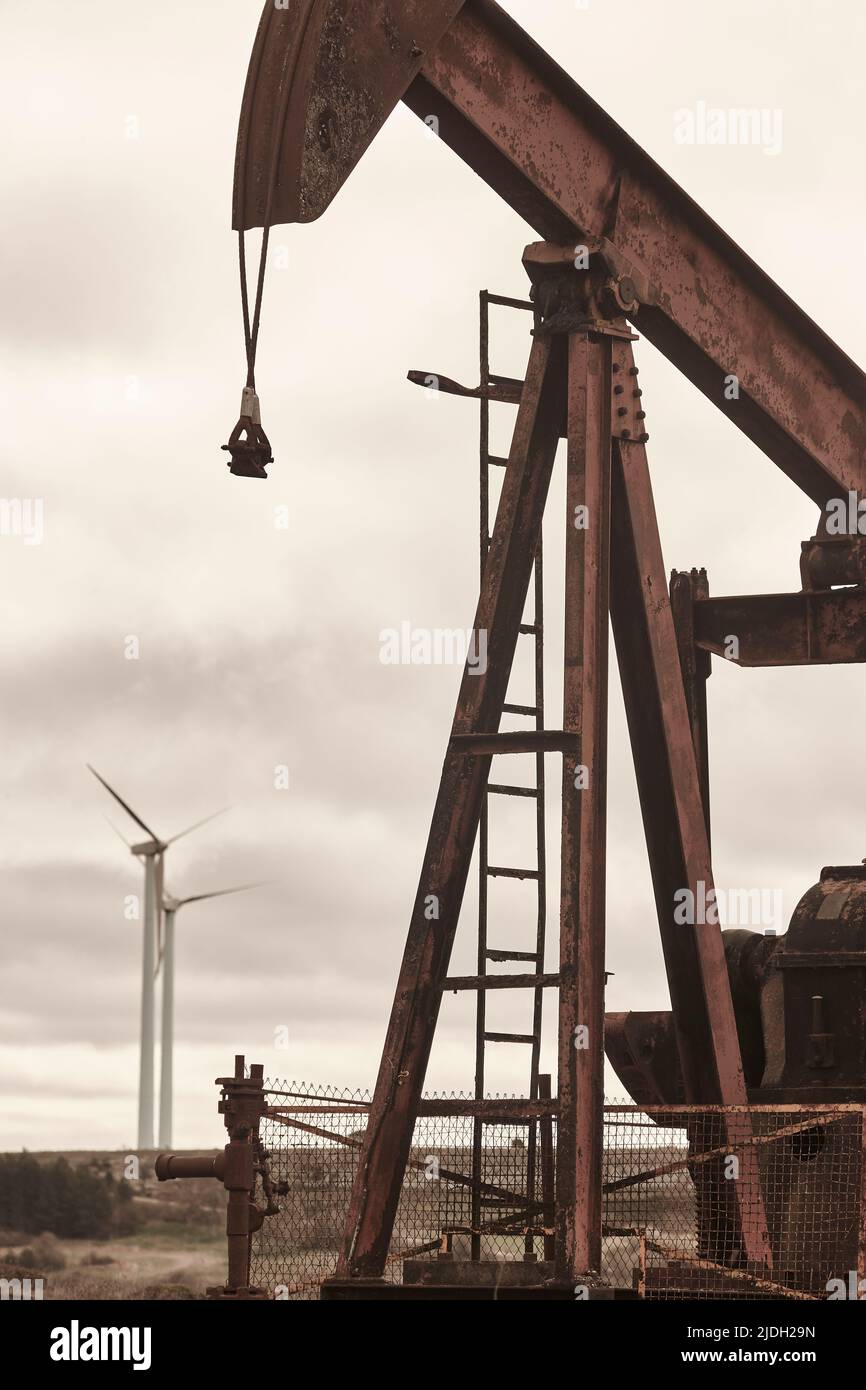 Oil pumping machine and windmills. Petroleum extraction. Resource Stock Photo