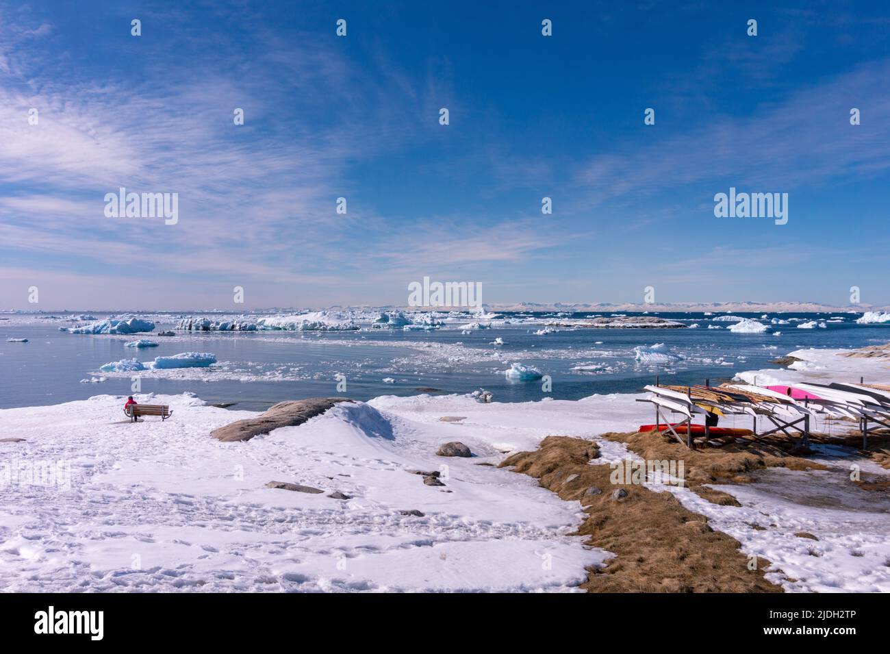 ilulissat landscape with sea and icebergs tourist woman on a bank Stock Photo