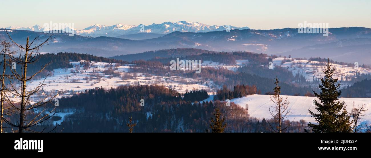Beskid Zywiecki and Tatra mountains from hiking trail bellow Tyniok hill summi above Koniakow villaget in winter Beskid Slaski mountains in Poland Stock Photo