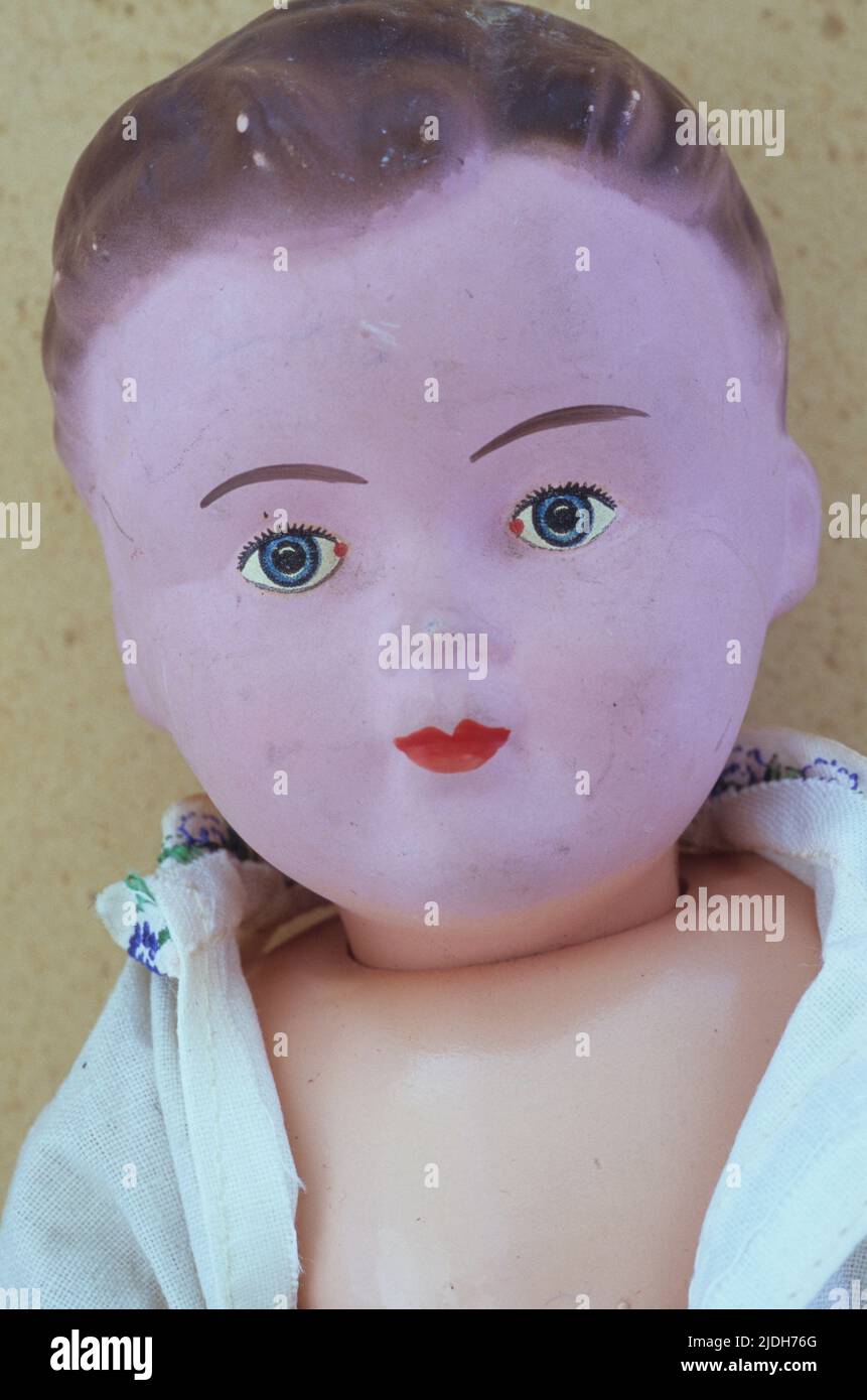 Head and chest of vintage boy doll with pink face and brown-pink body and wearing shirt in macho manner Stock Photo