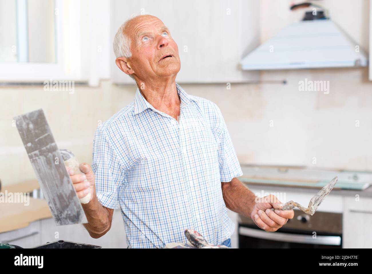 Man determining scope of plastering works Stock Photo
