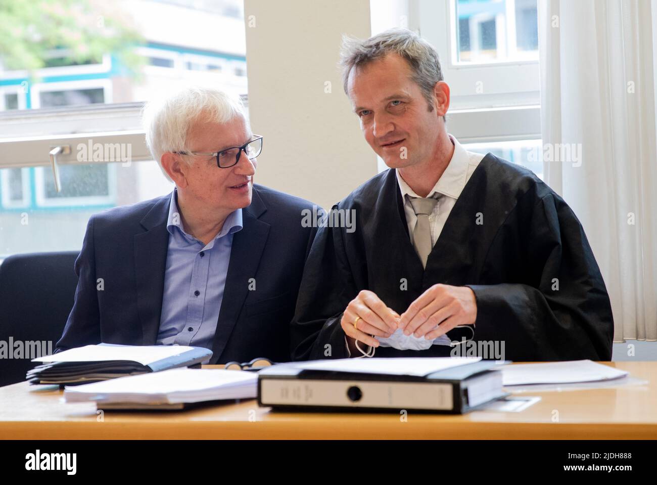 Stuttgart, Germany. 21st June, 2022. Jürgen Resch (l), Federal Executive Director of Deutsche Umwelthilfe (DUH), speaks with attorney Remo Klinger in a courtroom at Stuttgart Regional Court before the start of DUH's lawsuit against Mercedes-Benz. In the climate lawsuit, DUH is demanding that Mercedes-Benz transform the company in a climate-friendly way, in particular by reducing the CO2 emissions of its vehicles in line with the binding regulations of the Paris Climate Agreement and the German Climate Protection Act. Credit: Christoph Schmidt/dpa/Alamy Live News Stock Photo