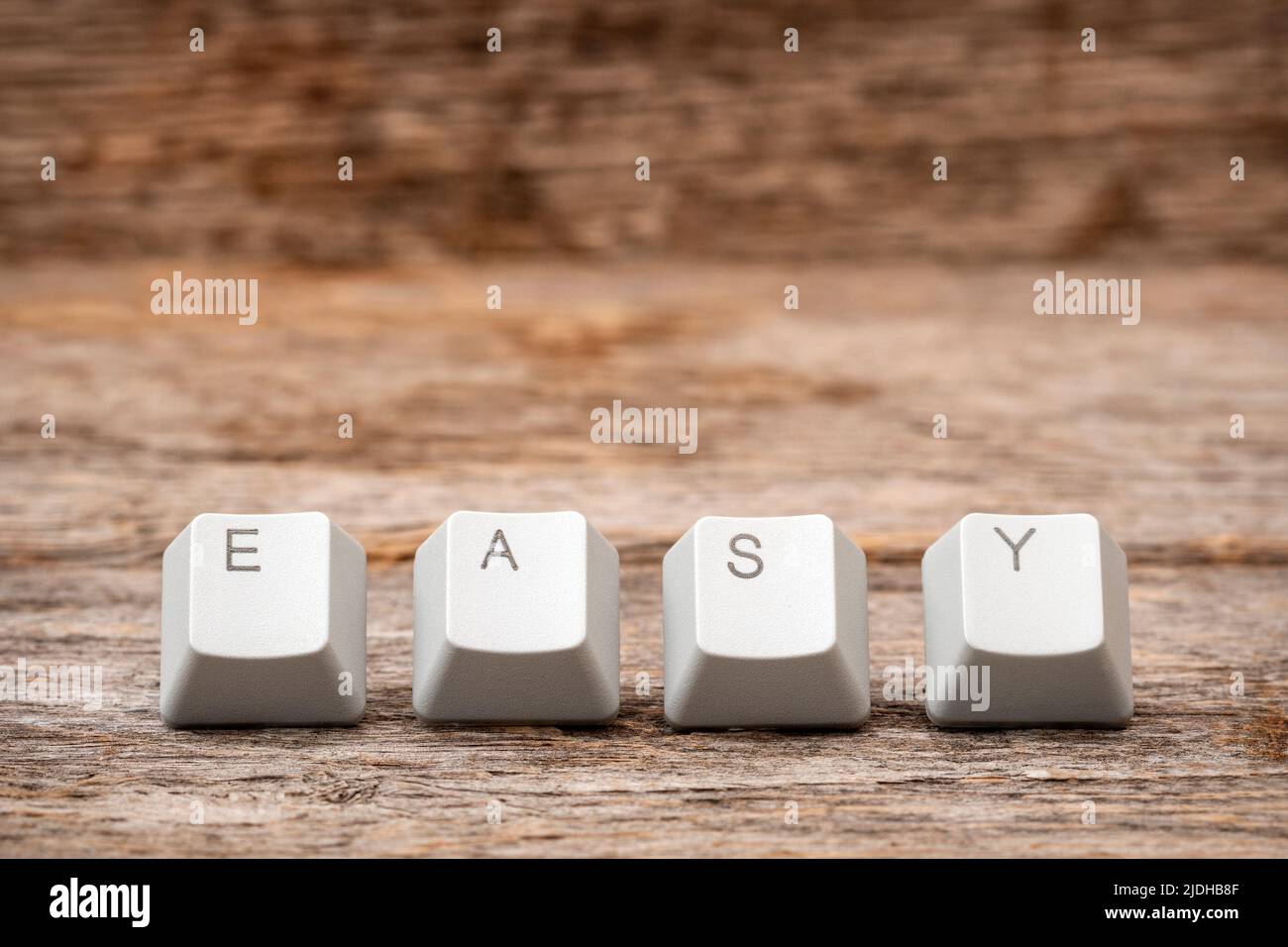 Computer keyboard keys arranged to spell EASY word on the wooden background Stock Photo