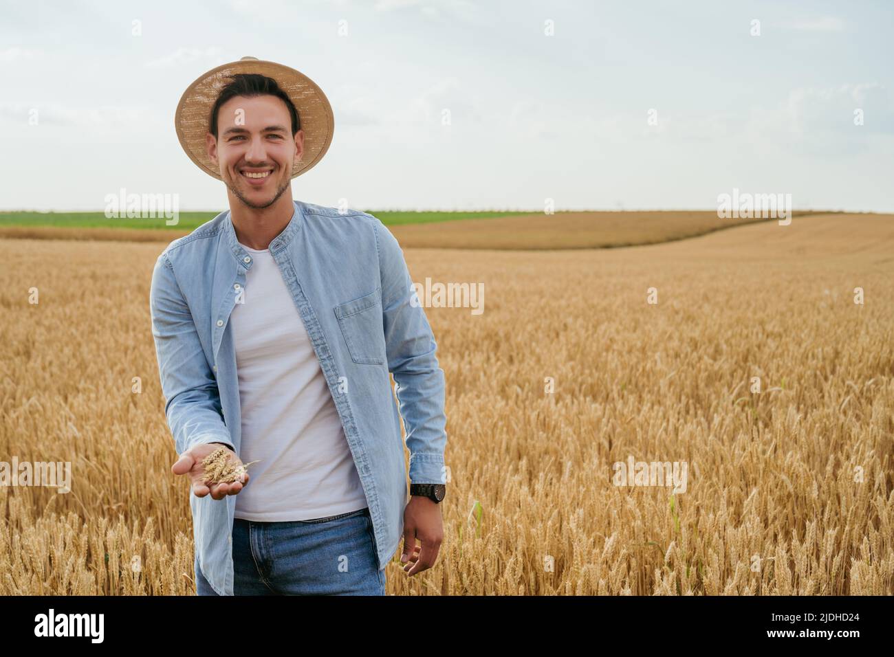 Happy farmer is standing in his growing wheat field Stock Photo - Alamy