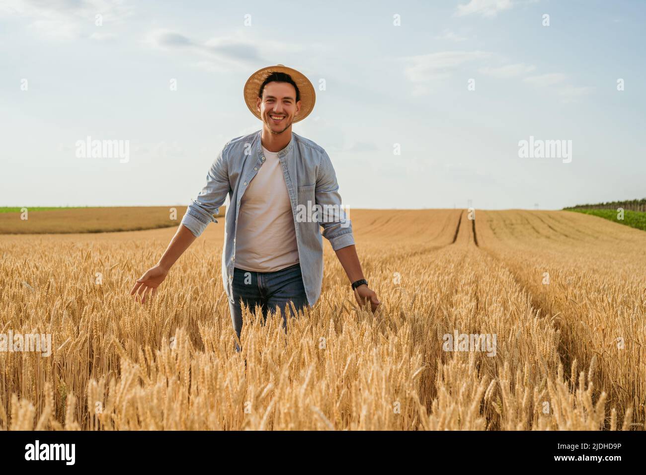 Happy farmer is standing in his growing wheat field Stock Photo - Alamy