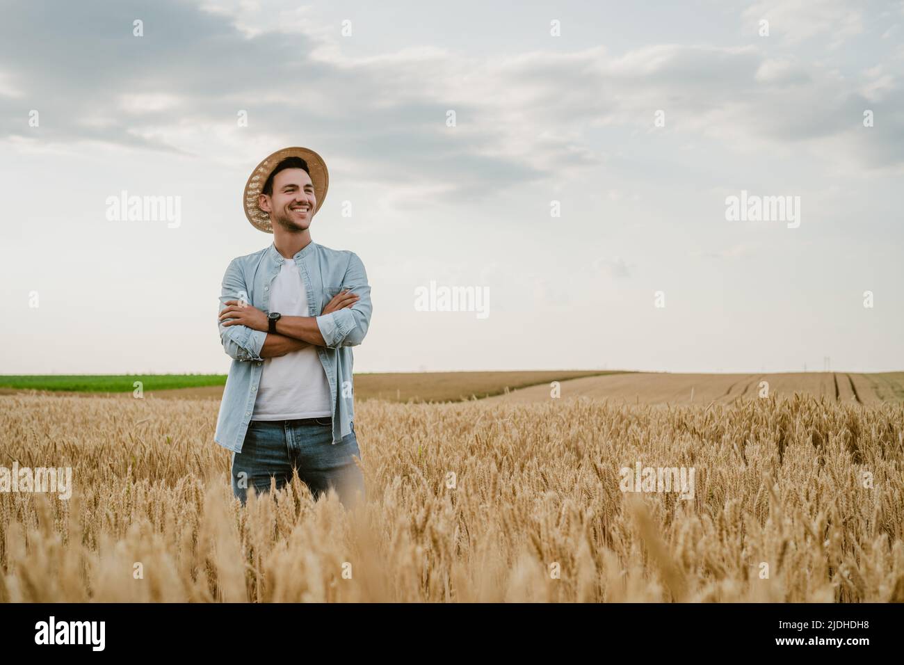 Happy farmer is standing in his growing wheat field Stock Photo - Alamy