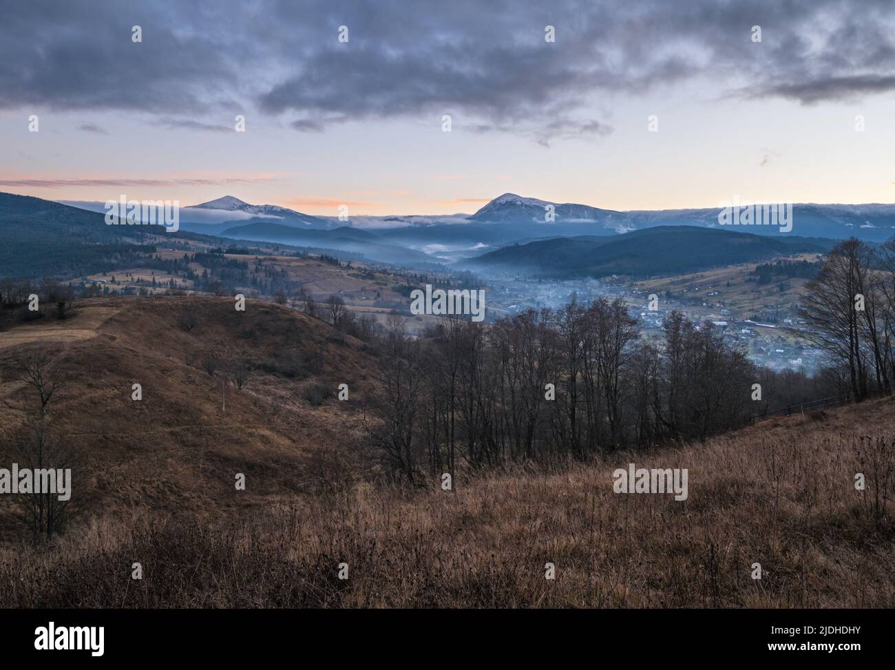 Picturesque pre sunrise morning above late autumn mountain countryside. Ukraine, Carpathian Mountains, Hoverla and Petros tops in far. Stock Photo