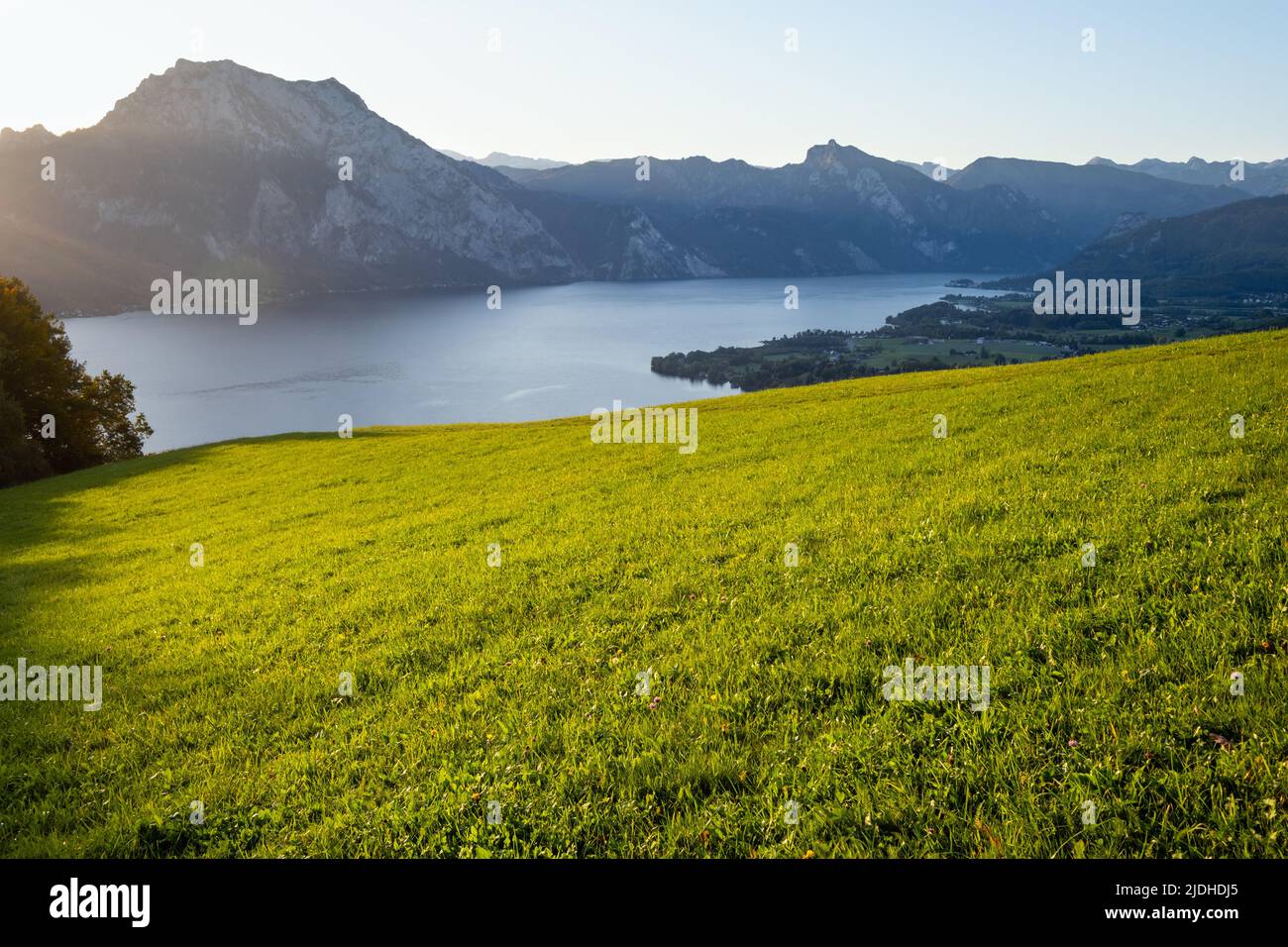 Peaceful autumn Alps mountain lake with clear transparent water and reflections. Sunrise view to Traunsee lake, Gmundnerberg, Altmunster am Traunsee, Stock Photo