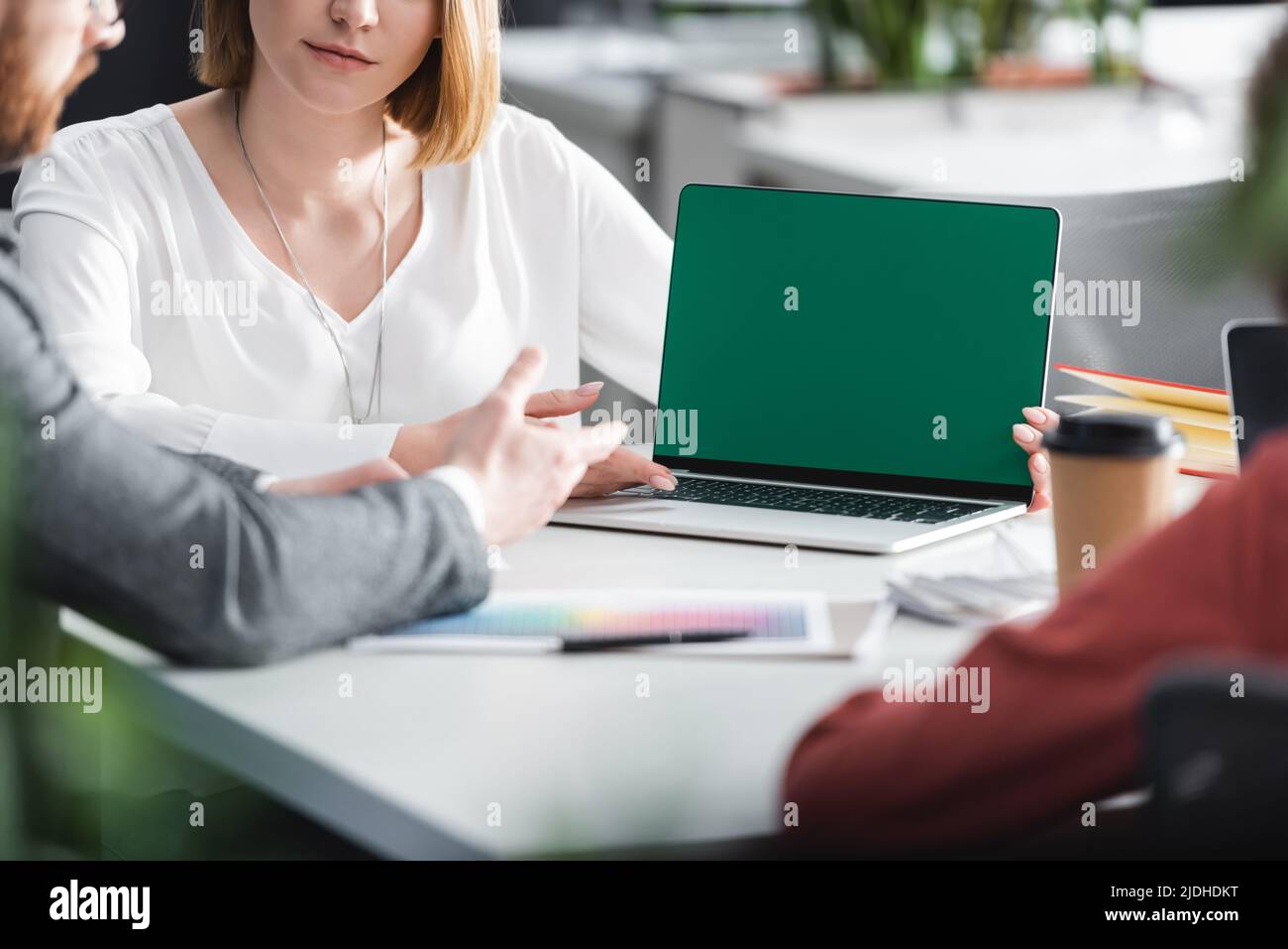 advertising managers pointing at laptop with green screen while working ...