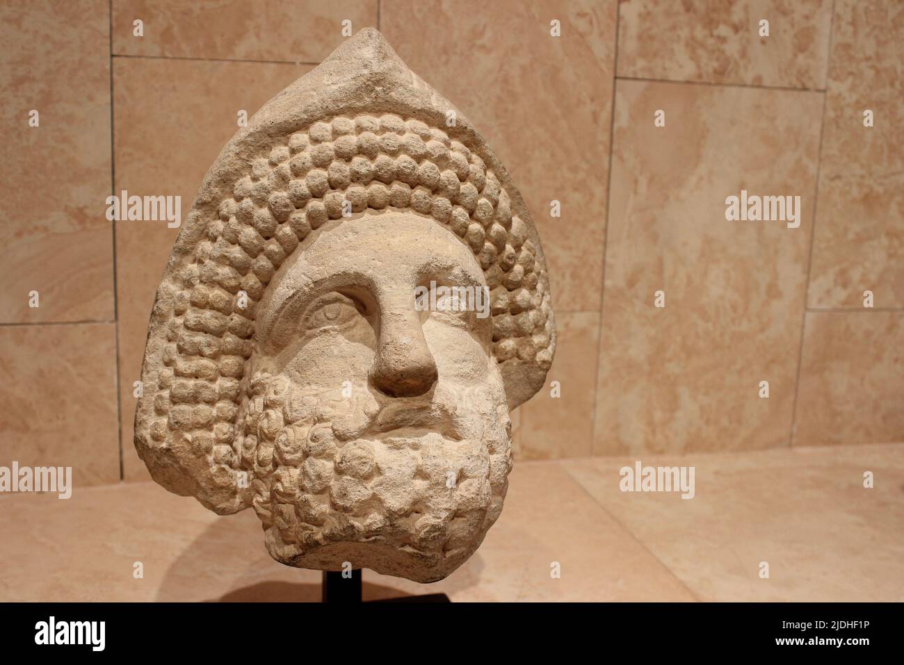 Head Of A Bearded Man With Curly Hair And Phrygian Cap - Possibly a Nabatean Priest. Raqmu - Petra, The Great Temple 1AD Stock Photo