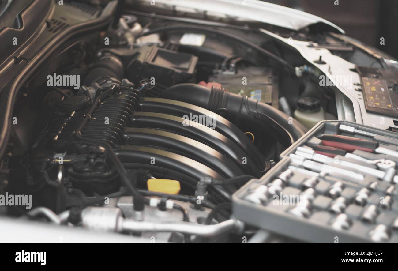 A set of socket wrenches lies on the car engine in the engine