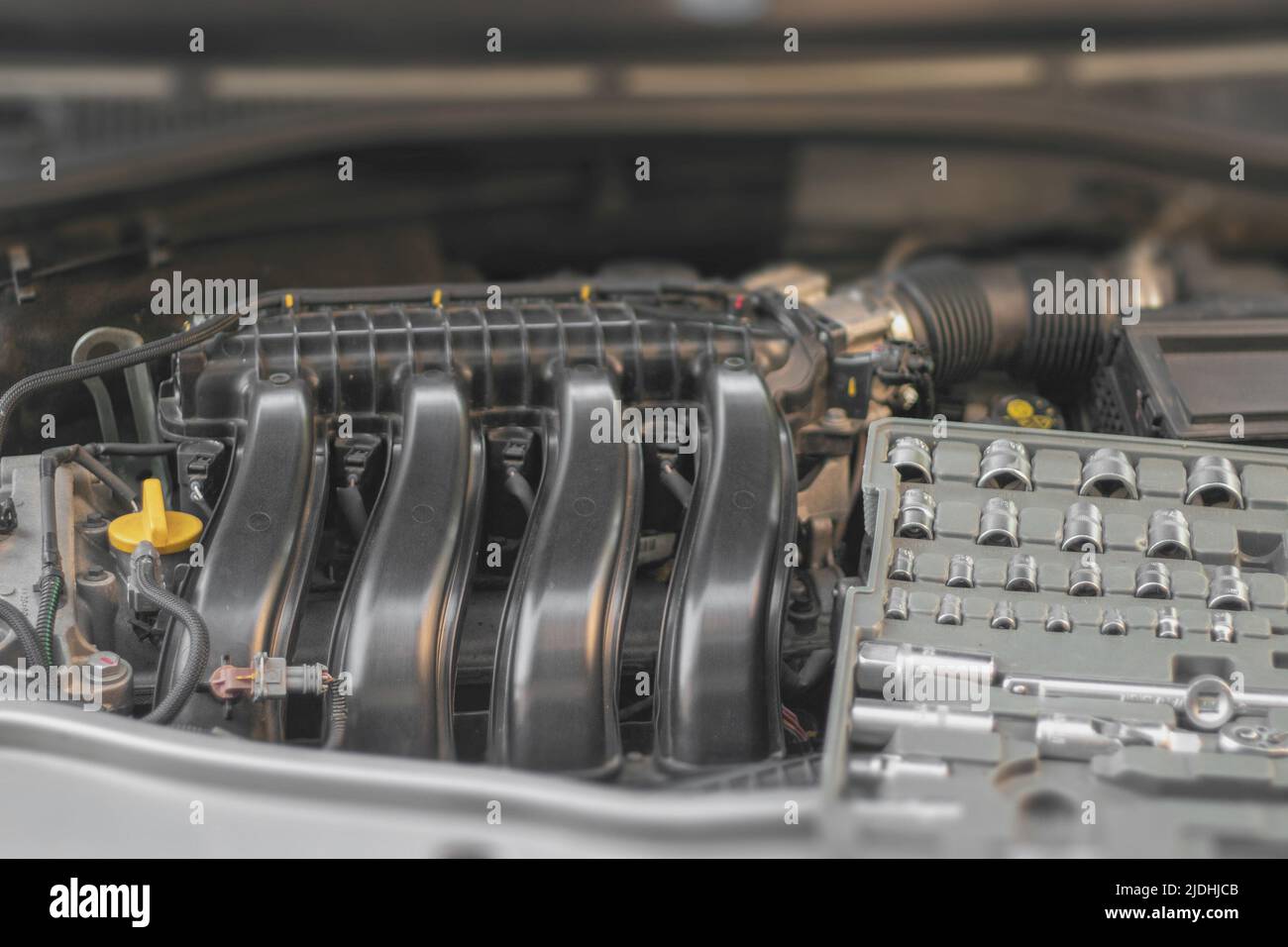 A set of socket wrenches lies on the car engine in the engine
